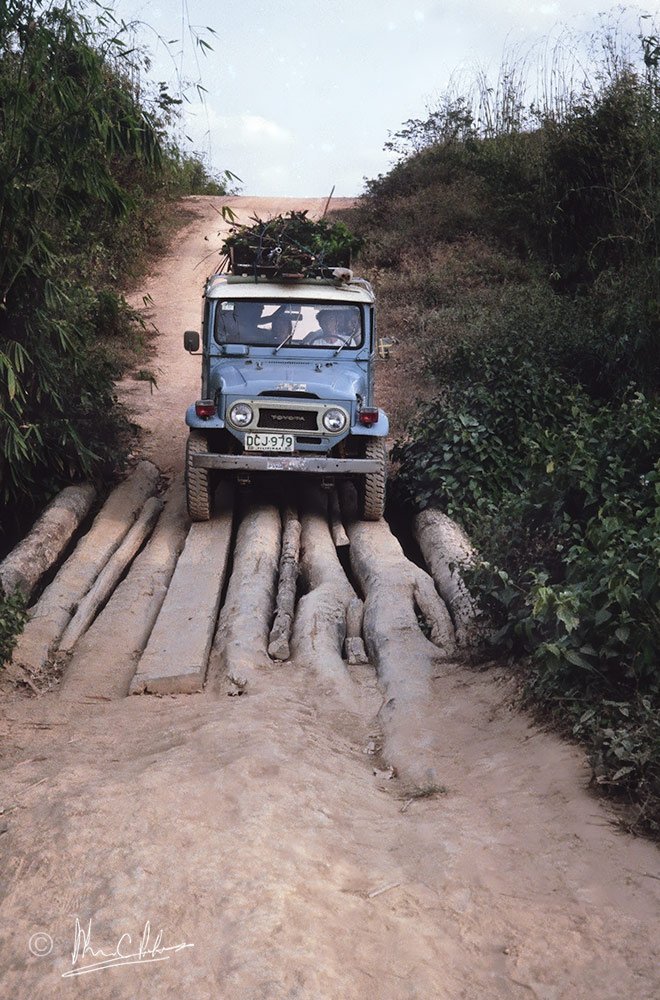 Car going over a log bridge